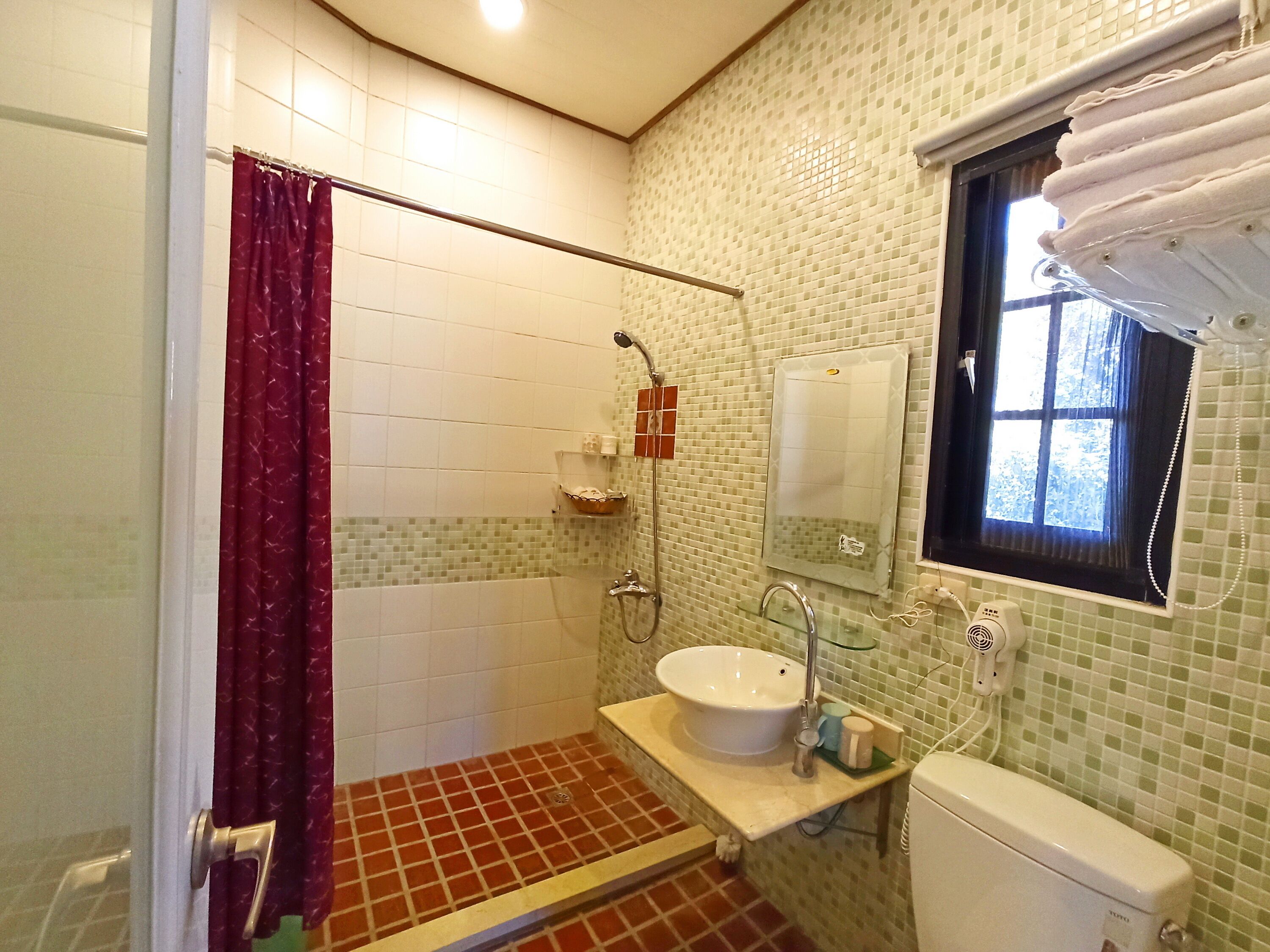 A bathroom with a shower, sink, and toilet.