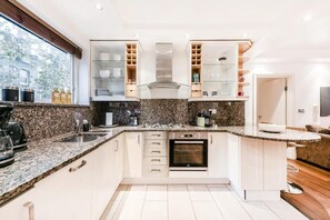 Deluxe appartement | Privékeuken | Een koelkast/vriezer, een magnetron, een oven, een vaatwasser