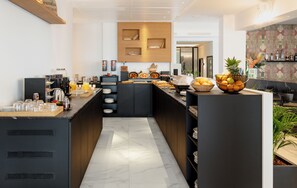 A modern breakfast bar with a variety of food items and beverages, a coffee station, and a decorative wall with a geometric pattern. - Stic Urban Hotel & Spa (Sant Antoni de Portmany)