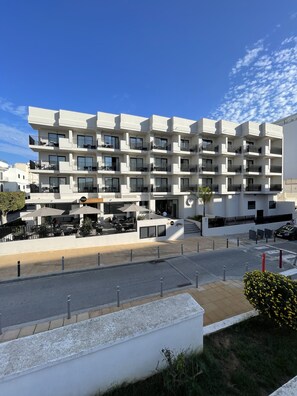 A multi-story hotel with balconies, outdoor seating, and a clear sky. - Stic Urban Hotel & Spa (Sant Antoni de Portmany)