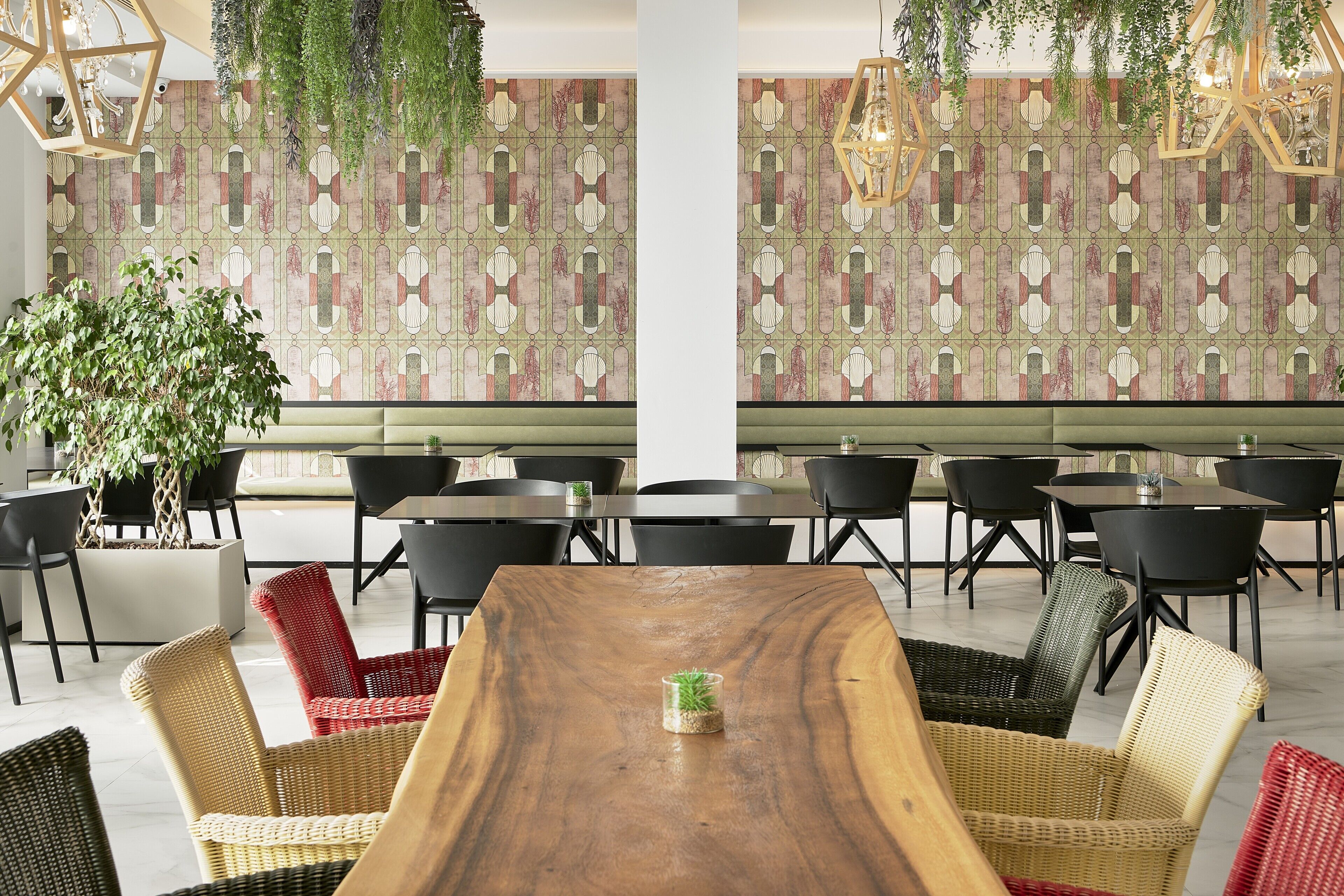 A dining area with a wooden table, wicker chairs, and a patterned wall.