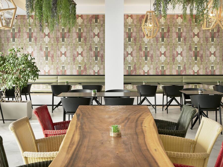 A dining area with a wooden table, wicker chairs, and a patterned wall.