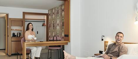 A modern hotel room with a bed, a desk, and a chair.