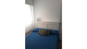 A bedroom with a bed, a window, and a door. - Downtown beach & peace (Málaga)