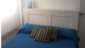 A bedroom with a bed, a window, and a door.