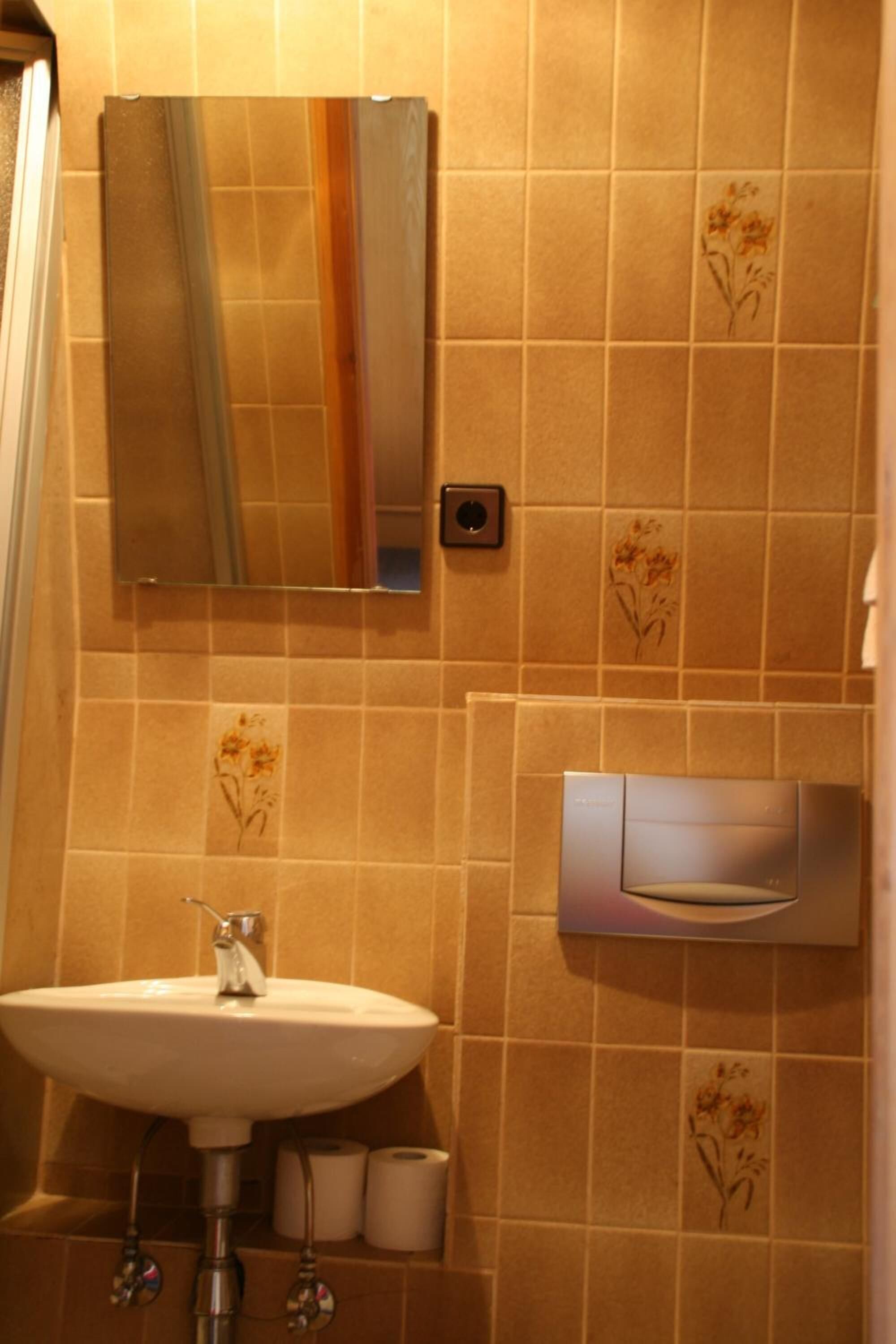 Ein Badezimmer mit Waschbecken, Spiegel und Handtuchhalter.