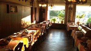 Un restaurante con paredes de madera, adornos de ciervas y una larga mesa de comedor con sillas.