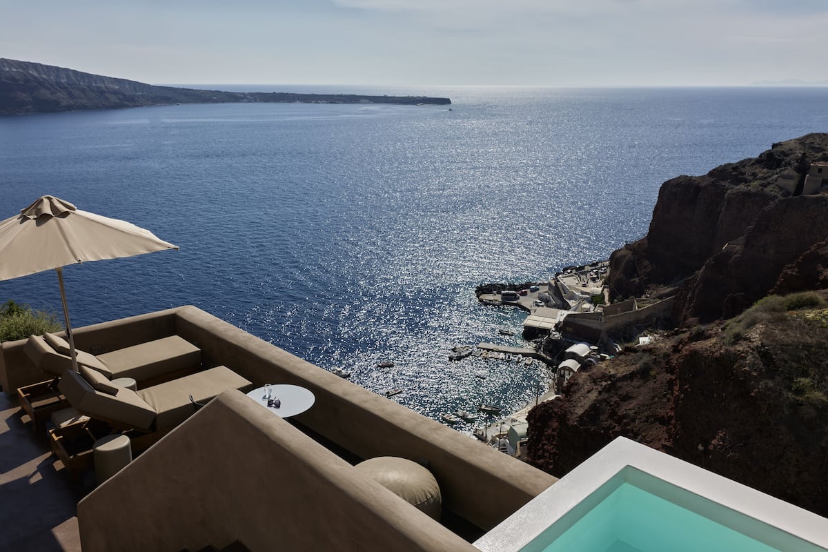 A seaside terrace with a pool, lounge chairs, and a view of the ocean.