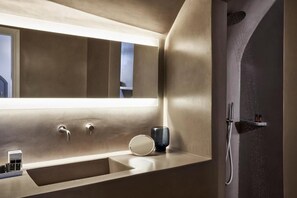 A modern bathroom with a large mirror, a sink, and a shower. - Old Castle Oia - Adults Only by Mr and Mrs White (Santorini)
