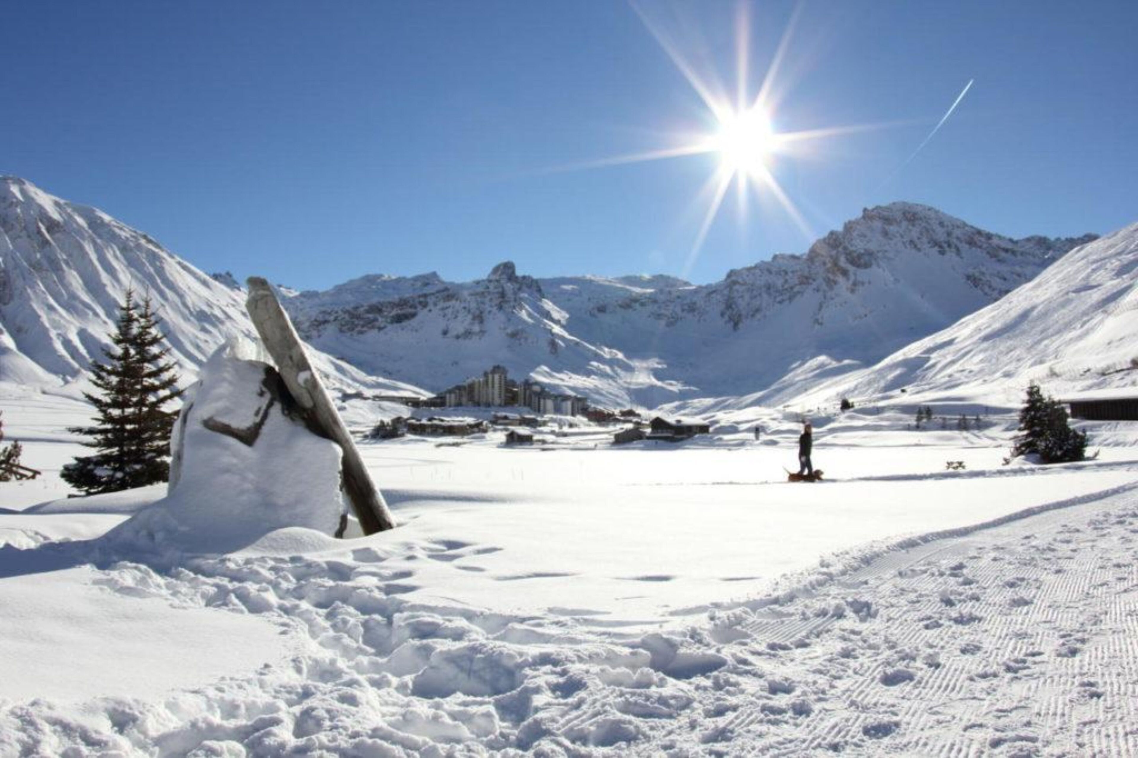 A snow-covered mountain landscape with a snowman and a clear sky.