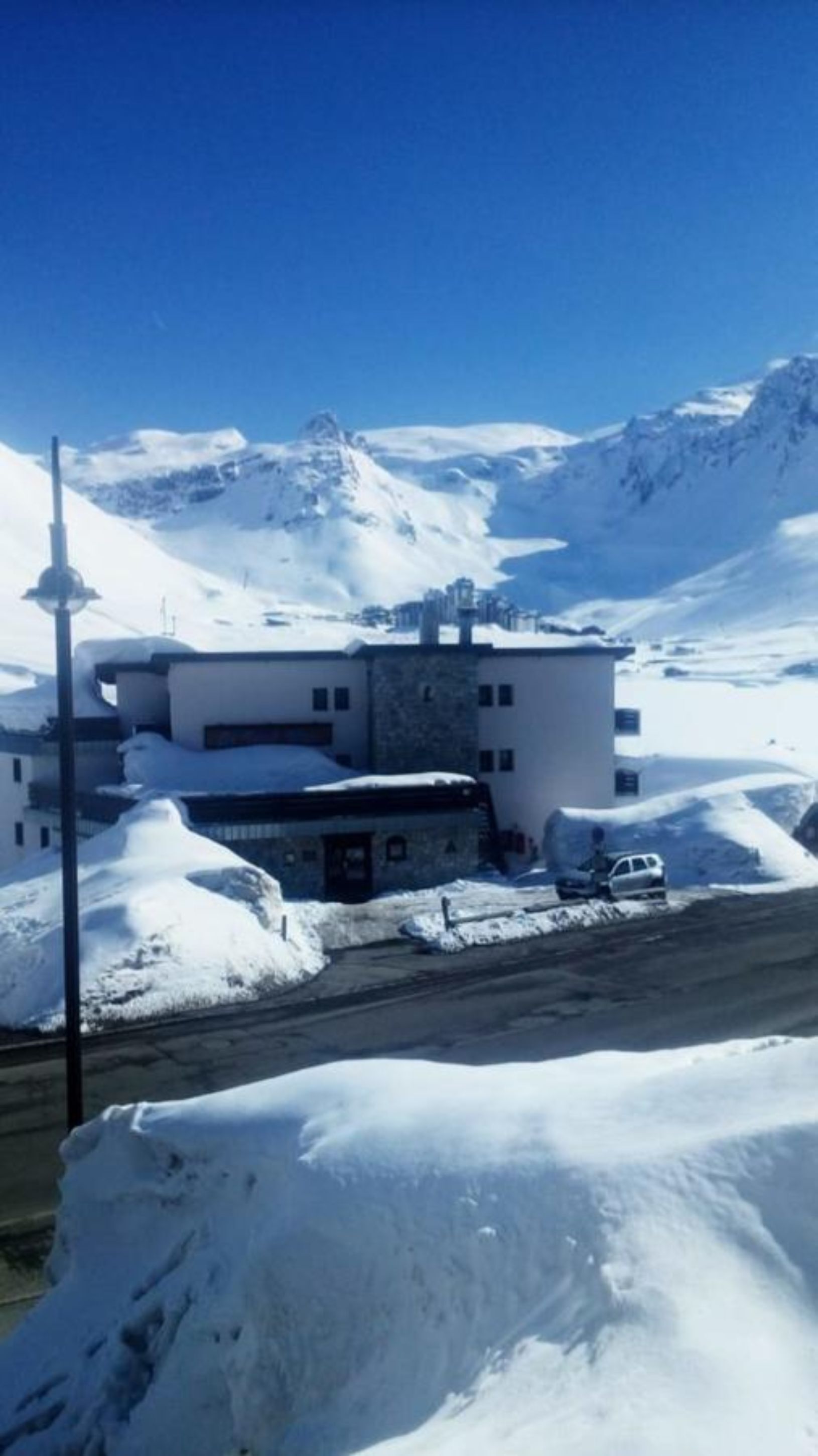 A snow-covered building with a flat roof and a small attached structure.