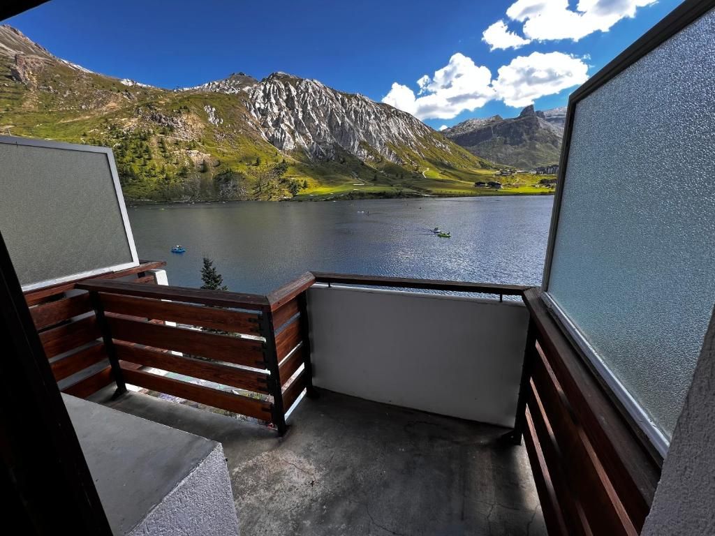 A balcony with a view of a lake and mountains.
