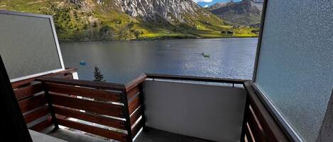 A balcony with a view of a lake and mountains.