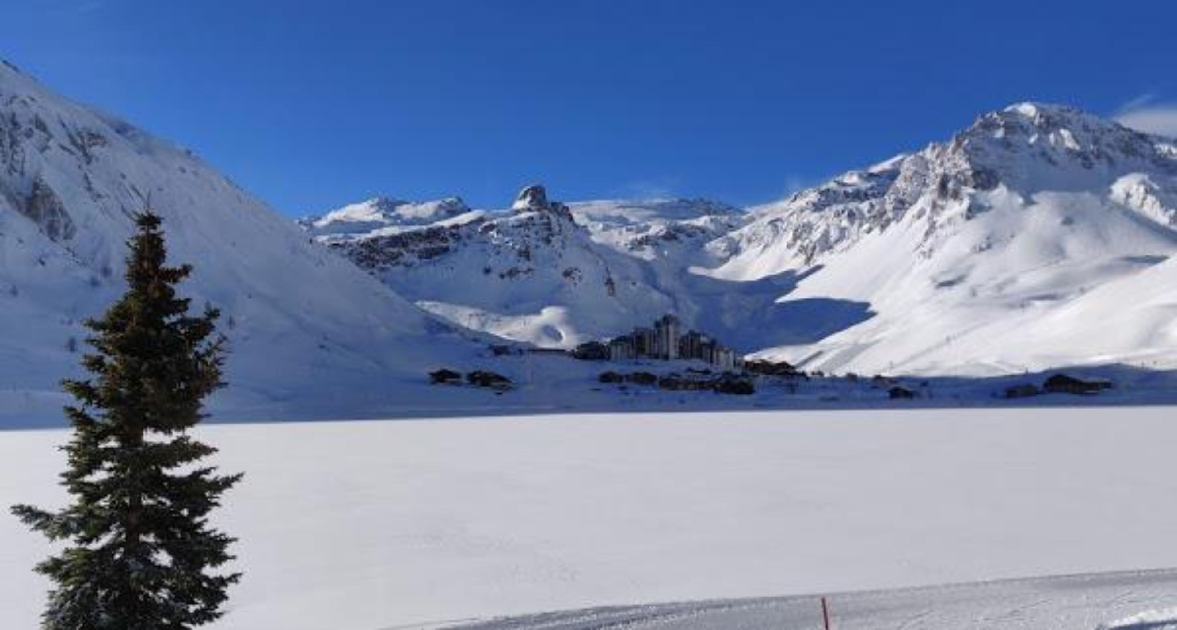 Un paisaje montañoso cubierto de nieve con cielo despejado.