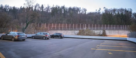 Un estacionamiento con tres automóviles estacionados.