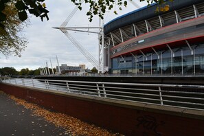 A stadium with a modern design, featuring a large open roof and a prominent bridge structure. - Luxury Apartment - Central Cardiff (Cardiff)