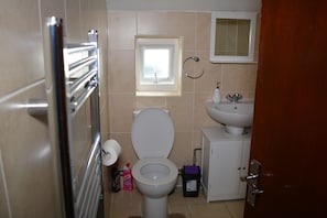 A bathroom with a toilet, sink, and window. - Luxury Apartment - Central Cardiff (Cardiff)