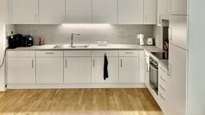 A modern kitchen with white cabinets, a stainless steel sink, and a built-in oven. - Central luxury apartment close to Prater / Messe / WU (Leopoldstadt)