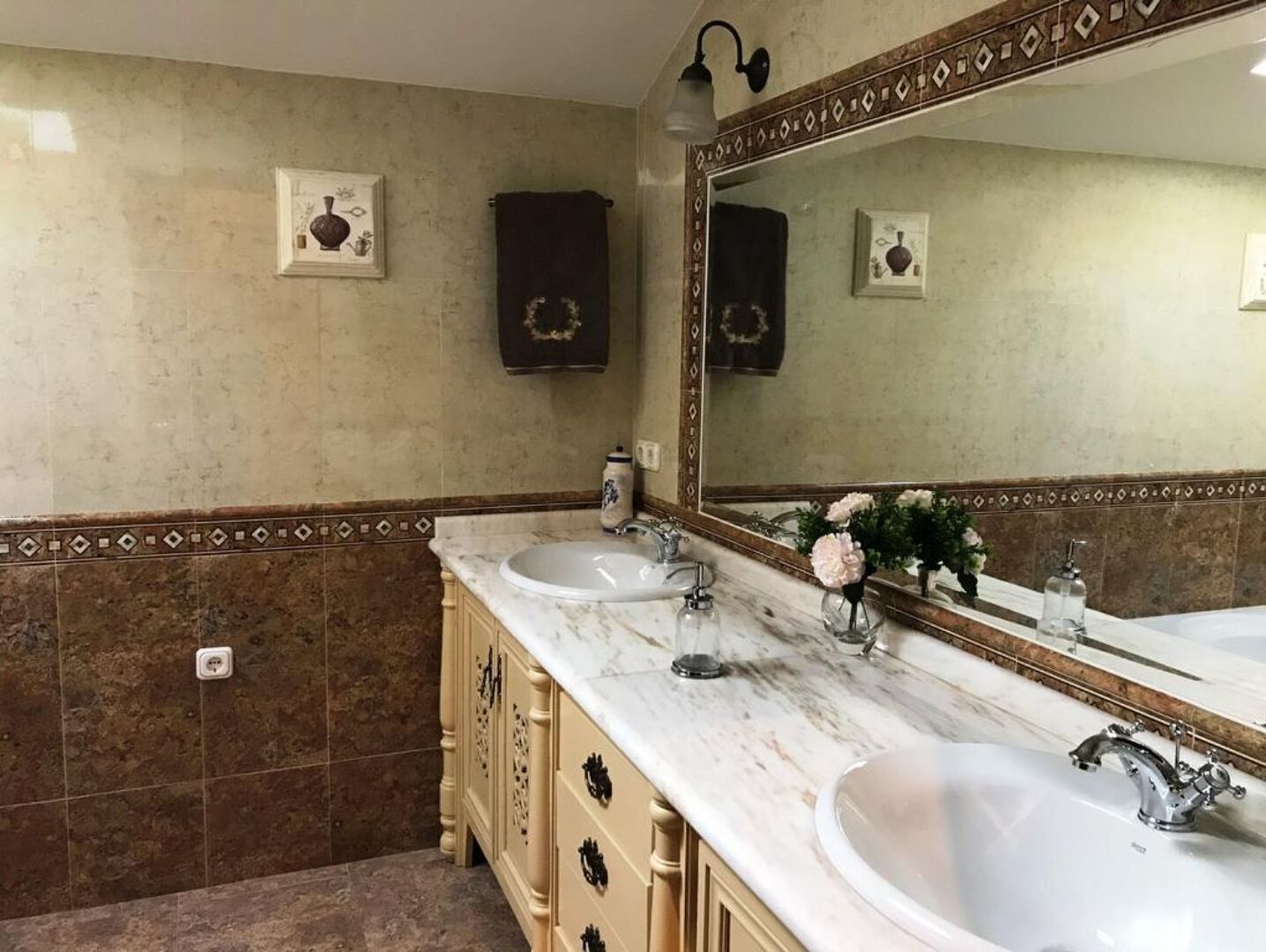 A bathroom with two sinks, a large mirror, and a towel rack.