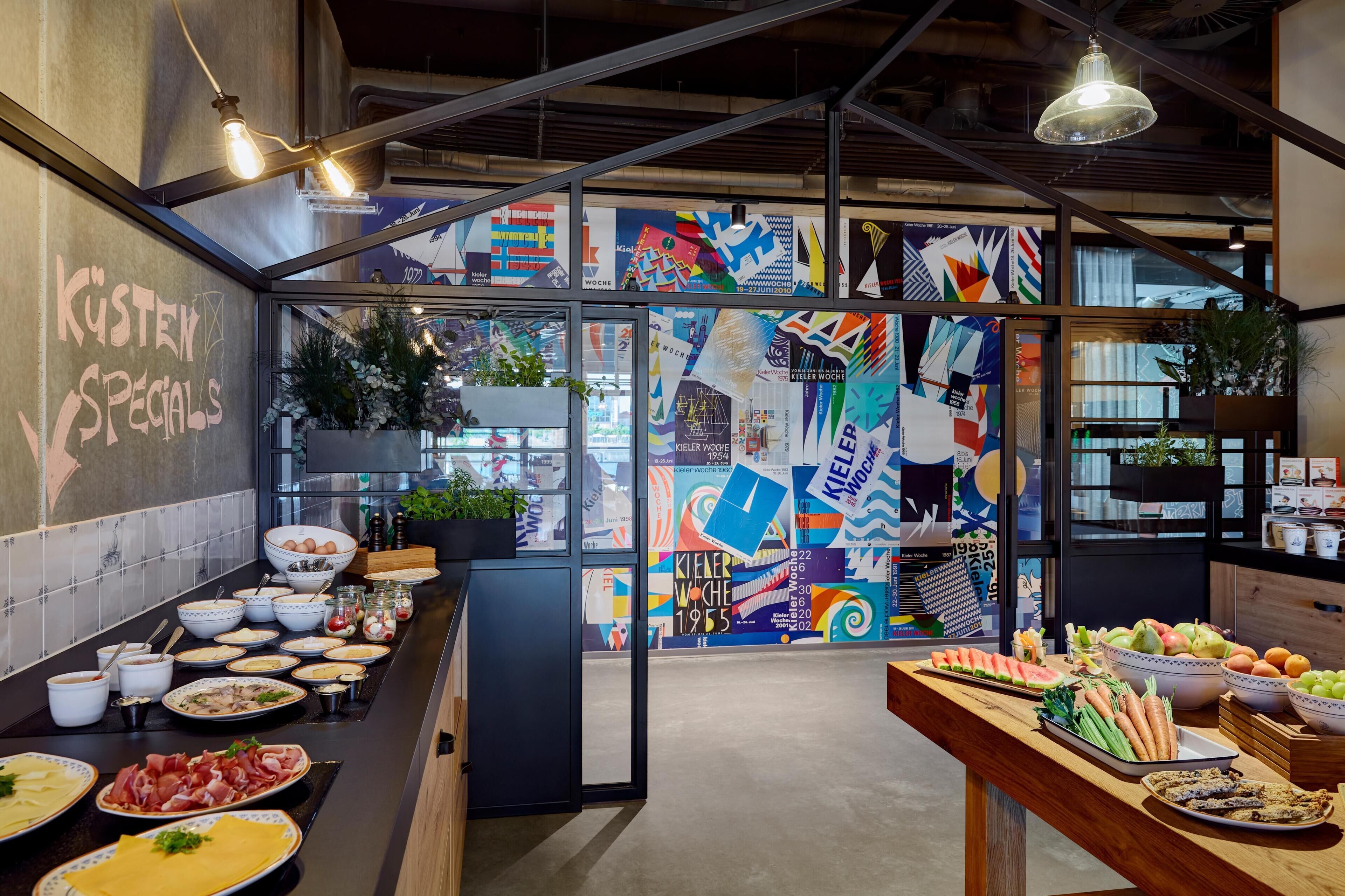 A modern kitchen with a variety of food items and a colorful wall mural.