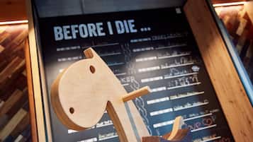 A wooden sculpture with a plaque in the background.
