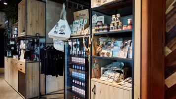 Un espacio comercial con estanterías de madera, un expositor refrigerado y diversos productos envasados.