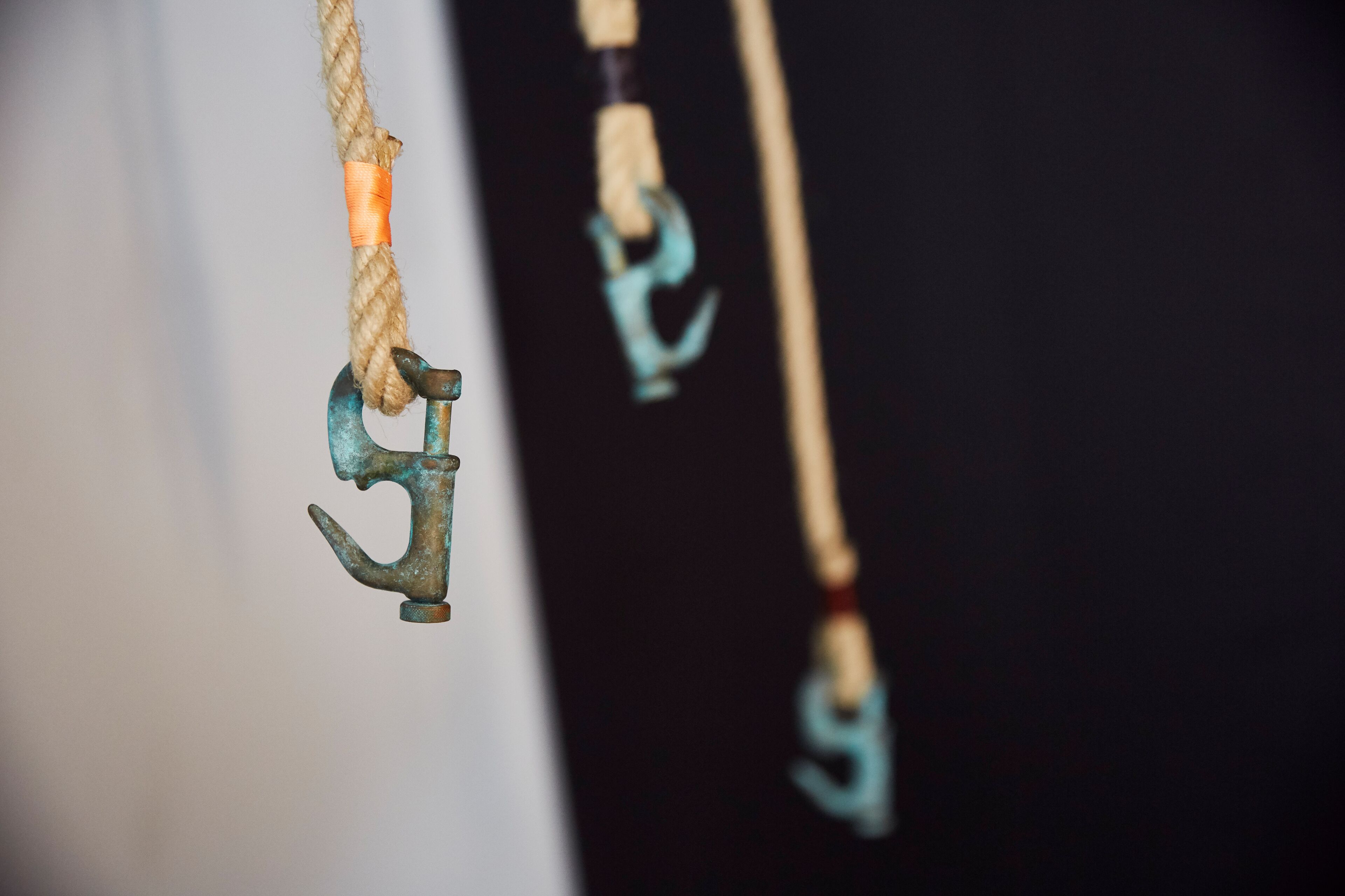 A close-up of a rope with a metal hook and a pulley system.