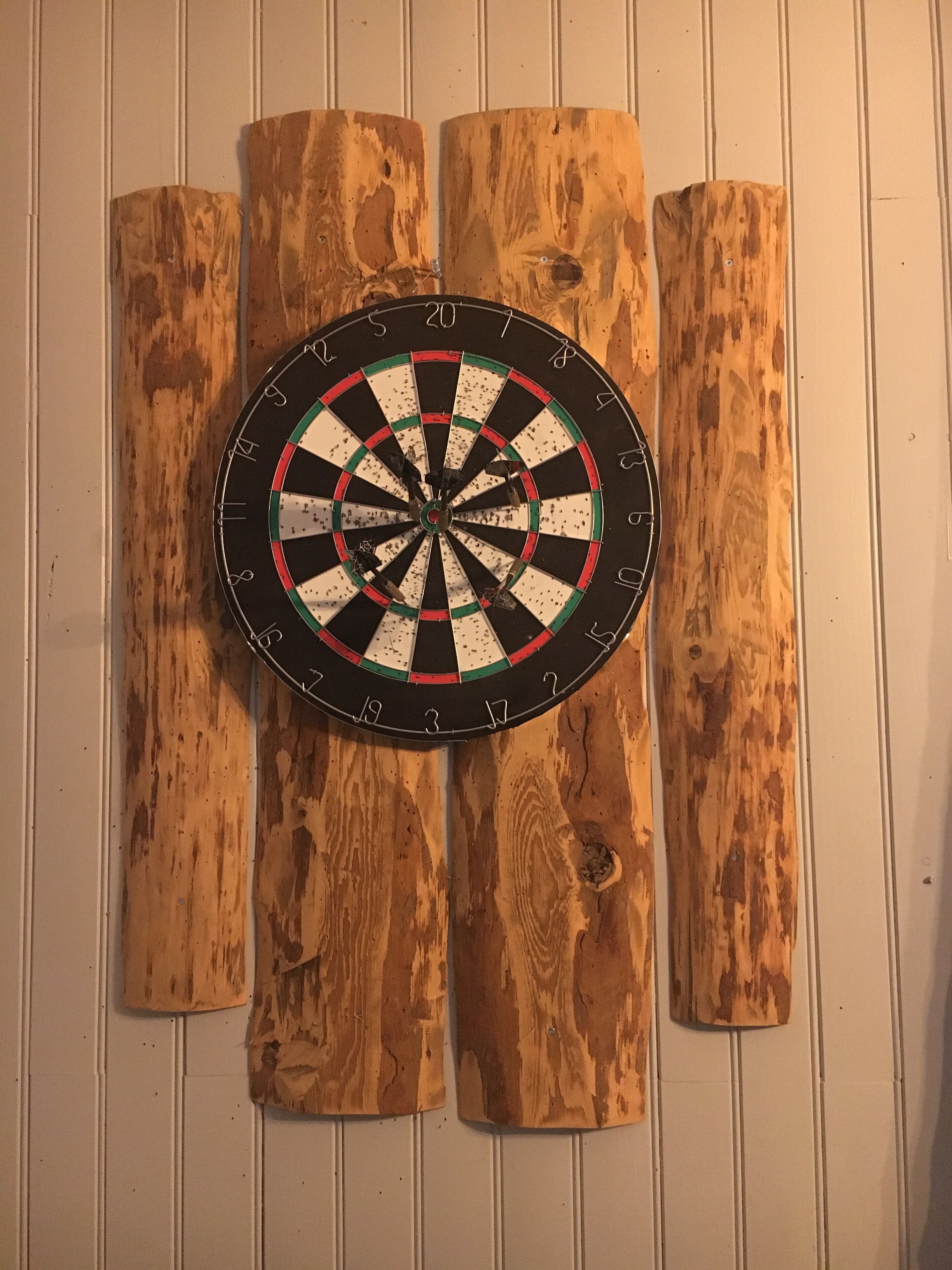 Eine Dartscheibe an einer Holzwand befestigt.