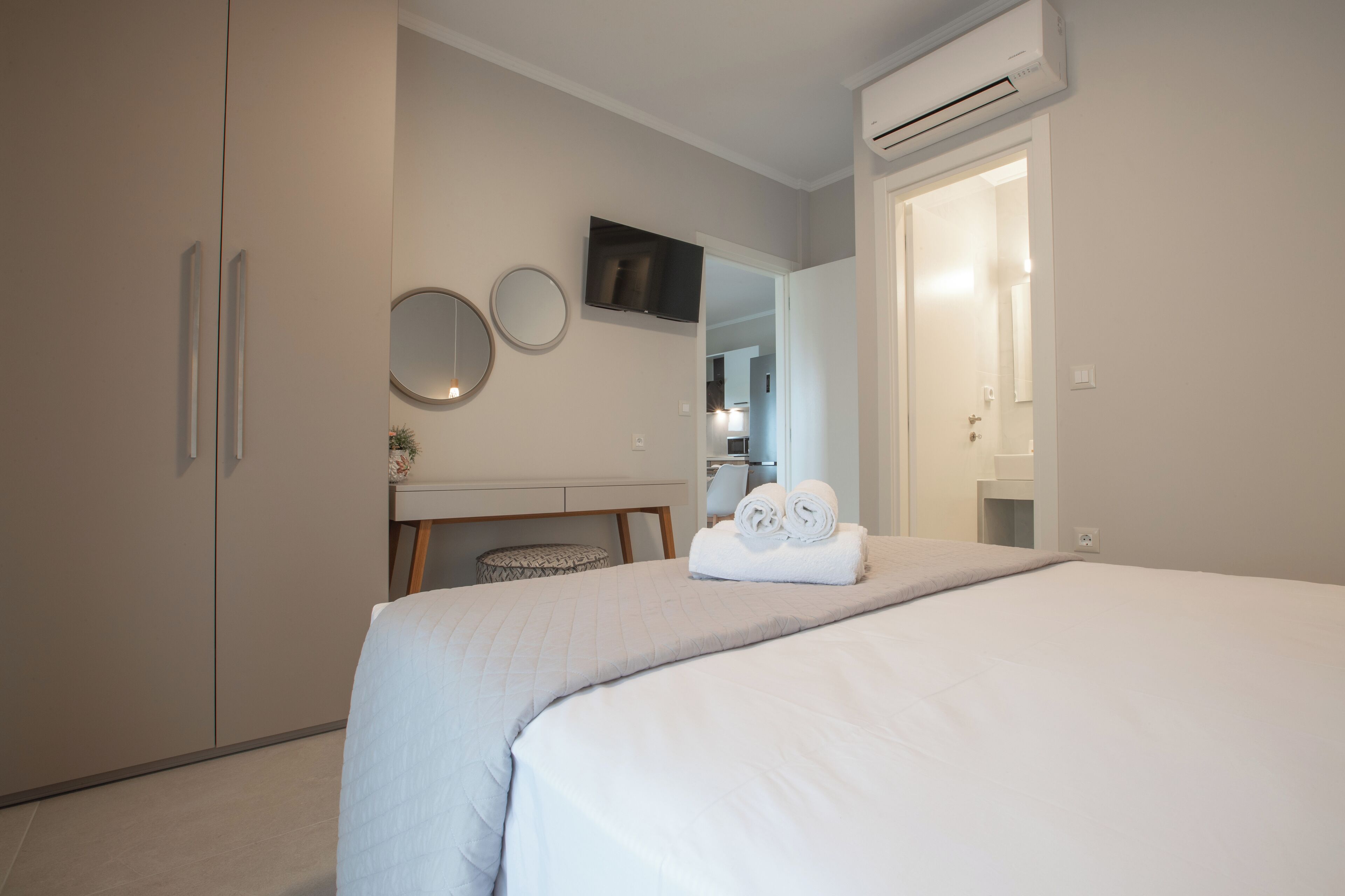 Ein modernes Schlafzimmer mit Bett, Schreibtisch und Kleiderschrank.