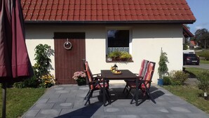 A house with a tiled roof, a wooden door, and a window with a flower box.