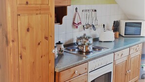 A kitchen with wooden cabinets, a microwave, and a stove.