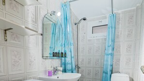 A bathroom with a washing machine, sink, toilet, and shower area. - Skioni Apartments (Kassandra)
