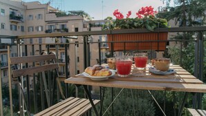 A balcony with a table set for breakfast, including croissants, coffee, and juice. - Vatican Garden Rooms (Rome)