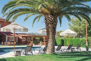 Una piscina al aire libre de temporada, sombrillas