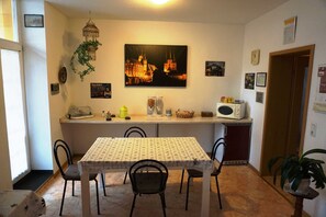A dining area with a table, chairs, a microwave, and a decorative plant.
