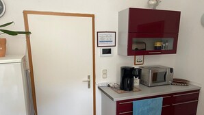A compact kitchen with a microwave, coffee maker, and a small refrigerator. - Holiday apartment - private room at the Ginkgo tree (Erfurt)