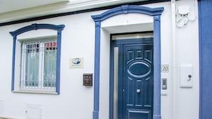 A building with a blue door and window, a mailbox, and a number plaque. - Praja Vecchia (Praia a Mare)