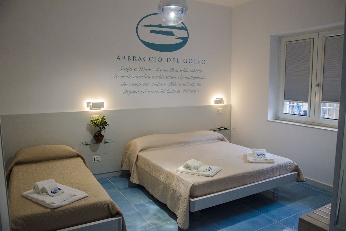 A hotel room with two beds, a wall-mounted sign, and a window.