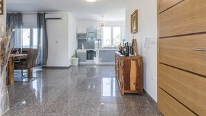 Une cuisine moderne dotée d’un îlot central, d’un coin repas avec une table et des chaises en bois, et d’une grande armoire en bois.