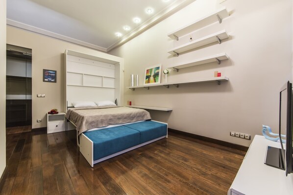 A modern bedroom with a bed, bedside tables, a desk, and built-in shelves. - Gorgeous Cozy Apartment at Horodetskogo (Kyiv)