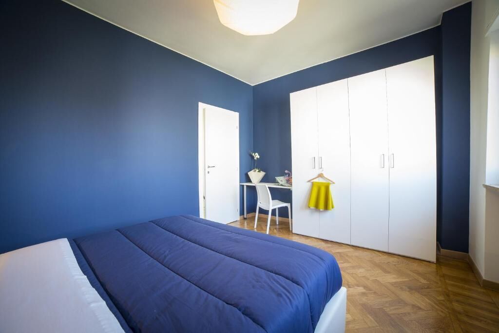 Un dormitorio con cama, escritorio y armario.