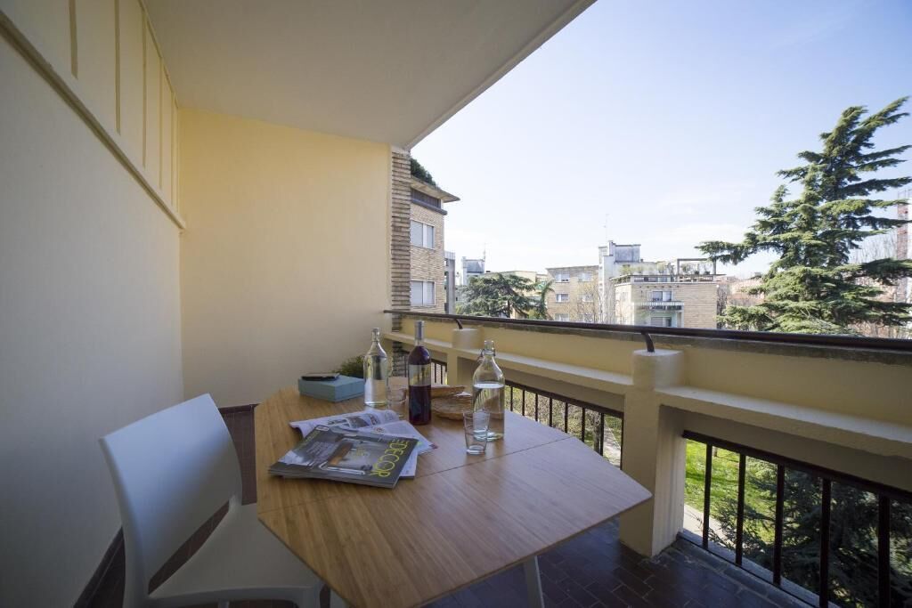 Un balcón con mesa, sillas y vista panorámica de la ciudad.