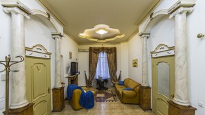 A spacious living room with a large sofa, a television, and a decorative rug. - Stylish Apartment Close ot the Opera (Kyiv)