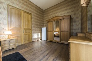 A room with wooden floors, a dresser, a mirror, and a wardrobe. - Magnificent Apartment at Luteranska (Kyiv)