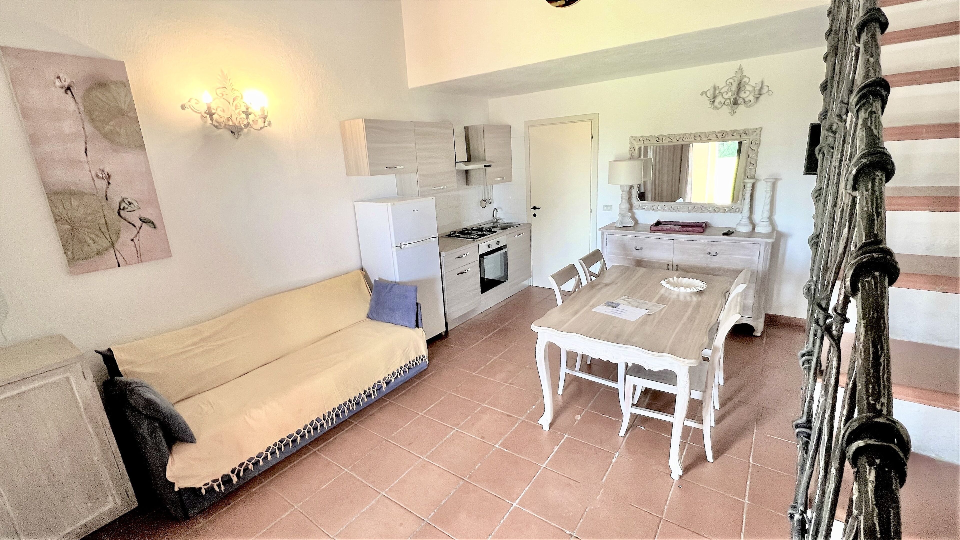 A compact living space with a kitchenette, a dining area, and a sofa.