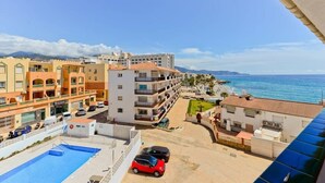 Un hotel costero con varias construcciones, piscina y vistas al mar.