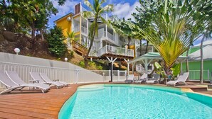 Un espace piscine avec des chaises longues et une terrasse en bois.