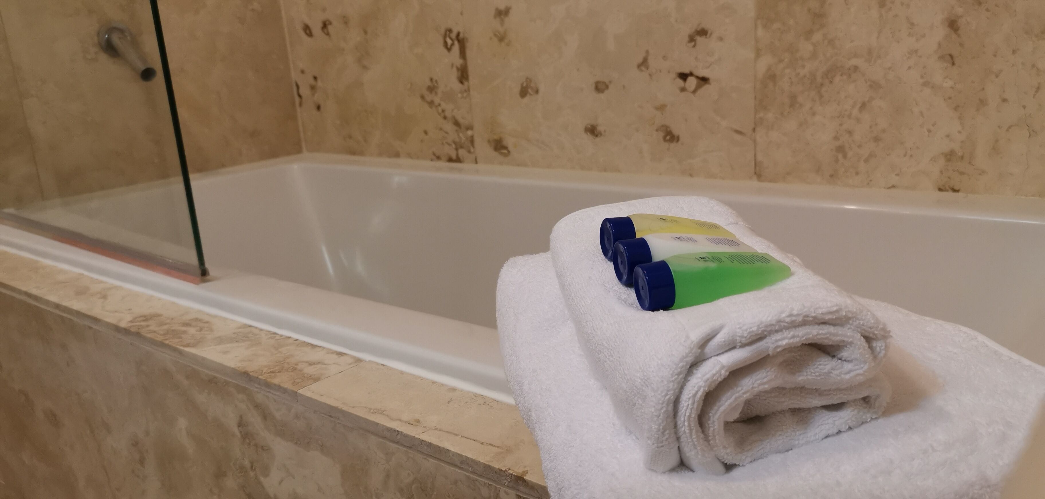 A white towel with toiletries on a bathroom counter.