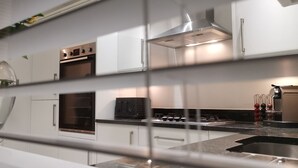 Une cuisine moderne équipée d’appareils électroménagers en acier inoxydable, d’un four encastré et d’une cuisinière à gaz.