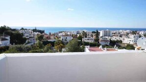 A coastal town with buildings, a clear sky, and the sea in the distance. - Paraiso Blanco (Nerja)